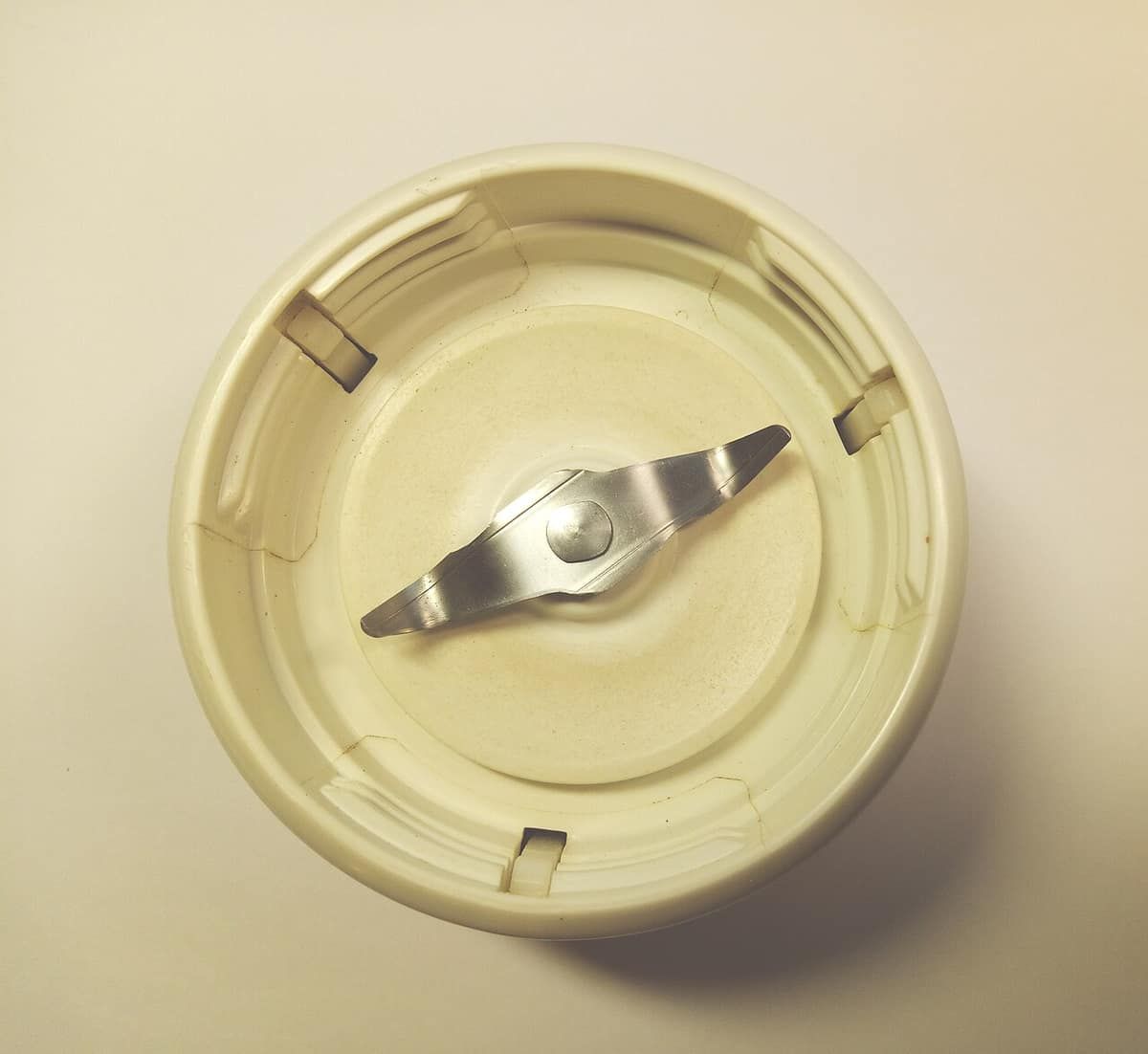 Top-down view of a blender blade assembly in a cream-colored base