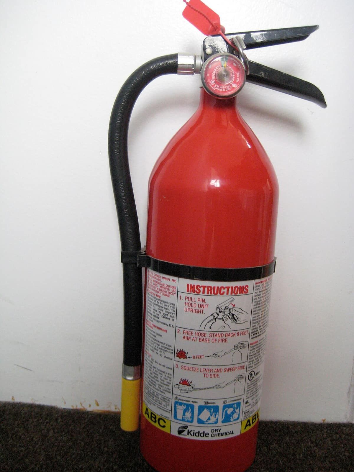 A red Kidde 5-pound ABC dry-chemical fire extinguisher standing on the floor