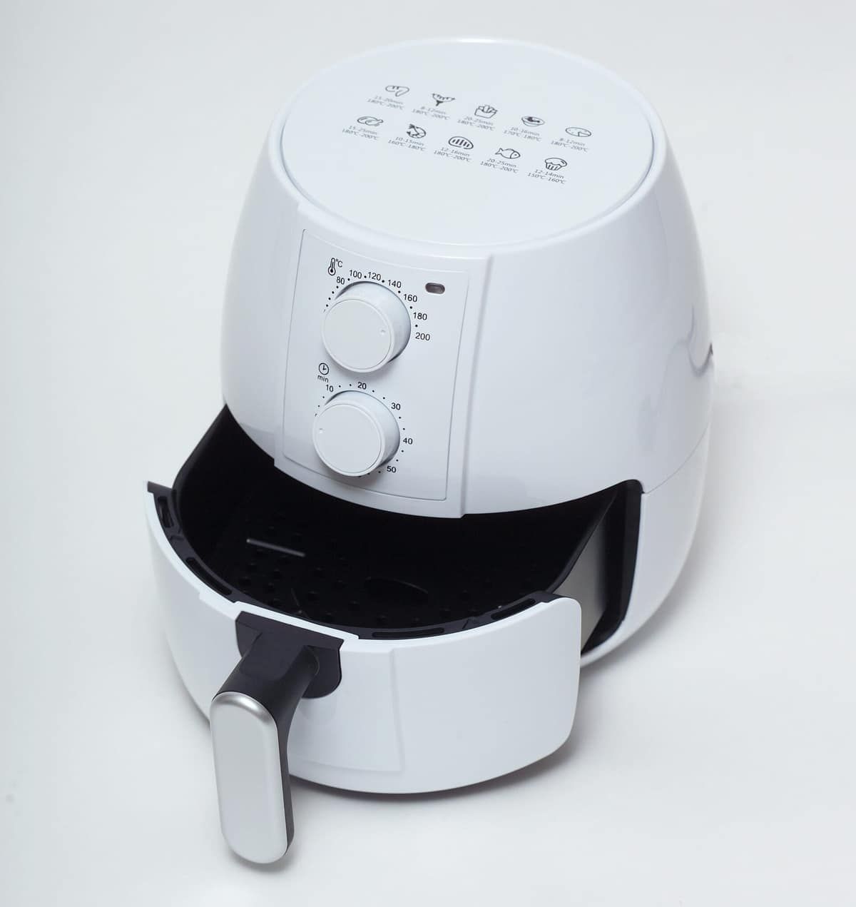 A white basket-style air fryer with its drawer pulled open, on a plain background