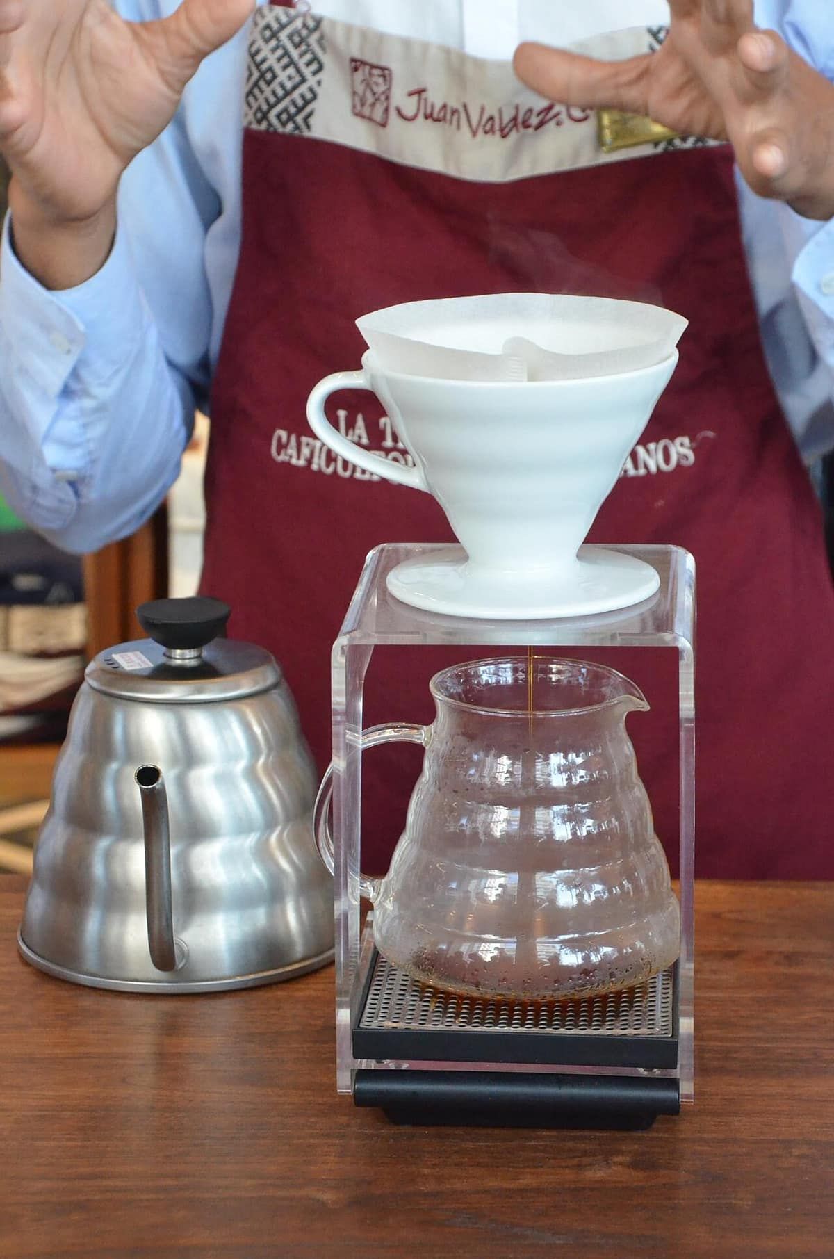 Coffee dripping from a pour-over cone into a glass server on a scale